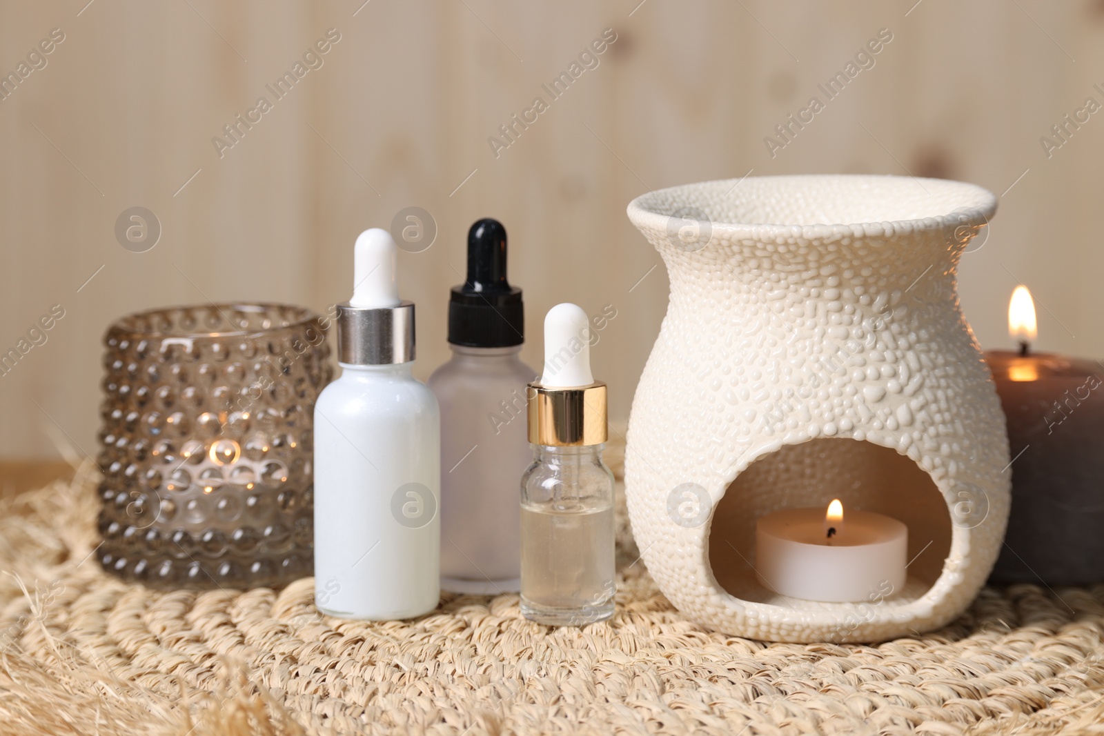 Photo of Different aromatherapy products and burning candles on table