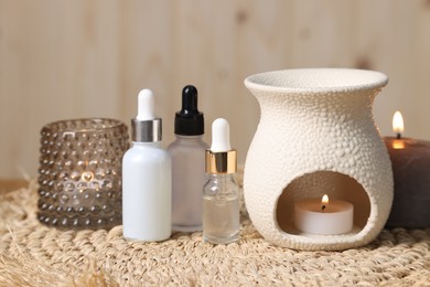 Different aromatherapy products and burning candles on table