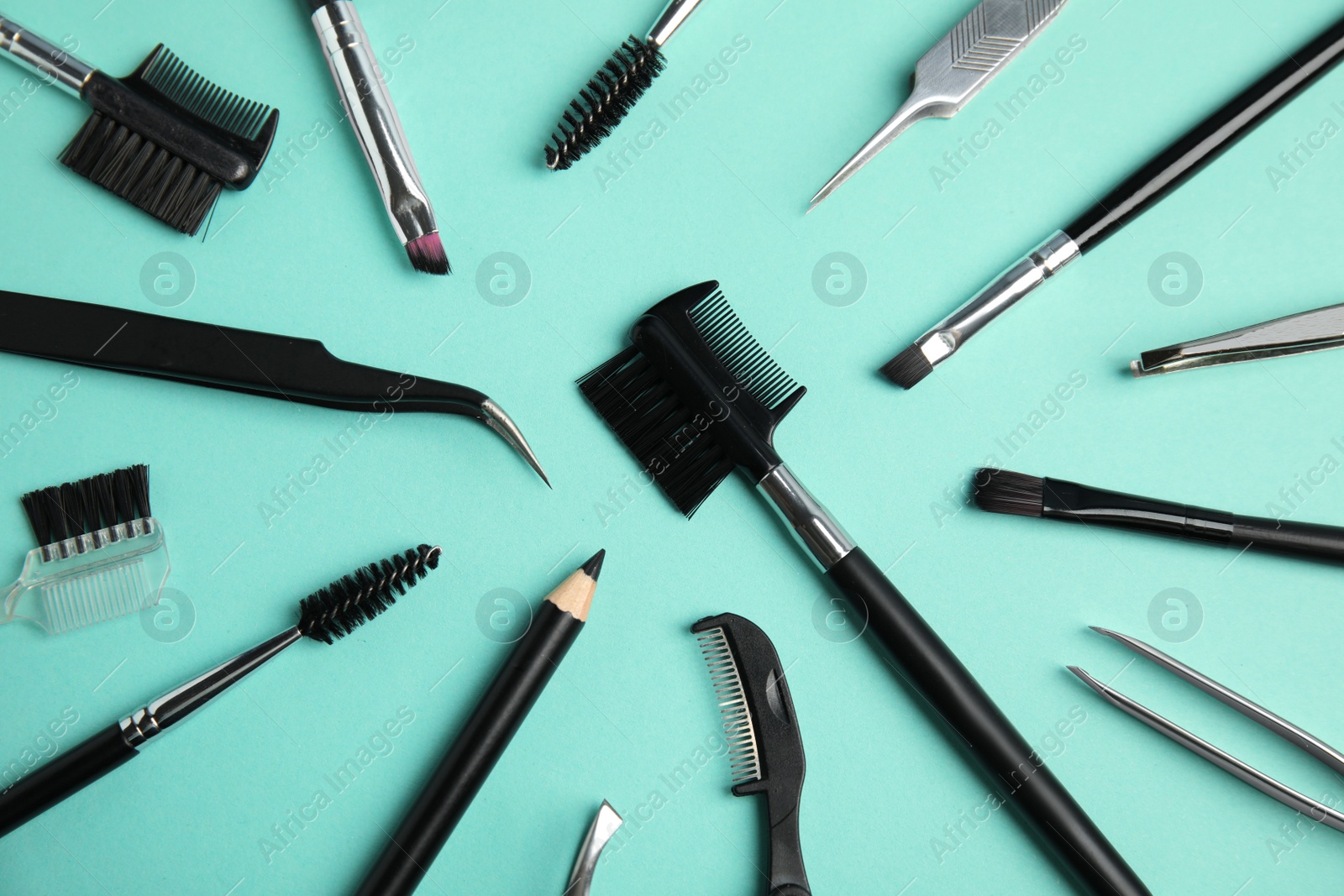 Photo of Set of professional eyebrow tools on turquoise background, flat lay