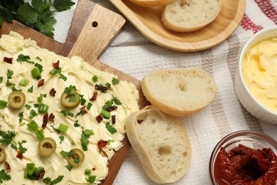 Photo of Fresh butter board with cut olives, sun-dried tomatoes and bread on table, flat lay