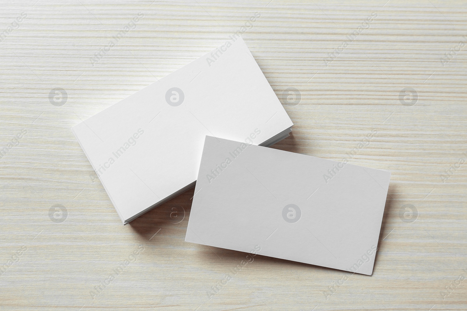 Photo of Blank business cards on white wooden table, flat lay. Mockup for design