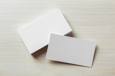 Blank business cards on white wooden table, flat lay. Mockup for design