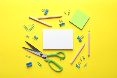 Flat lay composition with scissors and office supplies on color background. Space for text