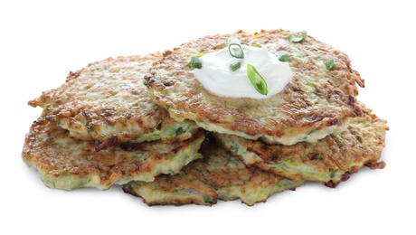 Delicious zucchini fritters with sour cream and green onion on white background