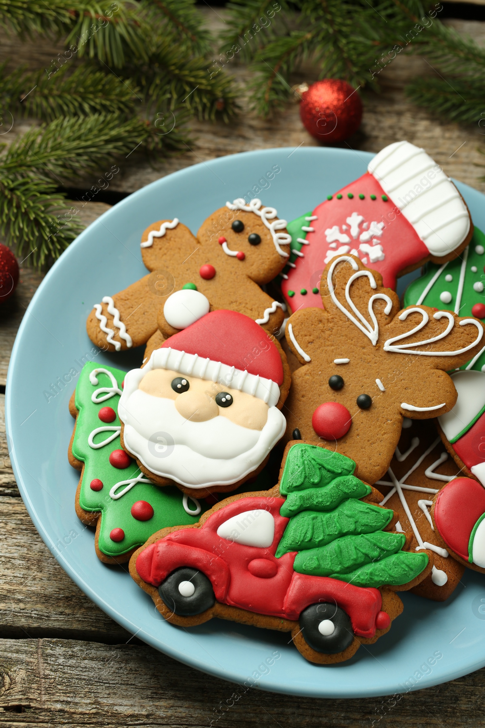 Photo of Different tasty Christmas cookies and fir tree branches on wooden table, above view