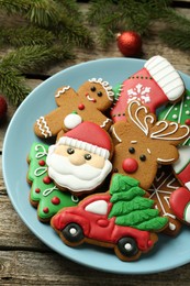 Photo of Different tasty Christmas cookies and fir tree branches on wooden table, above view