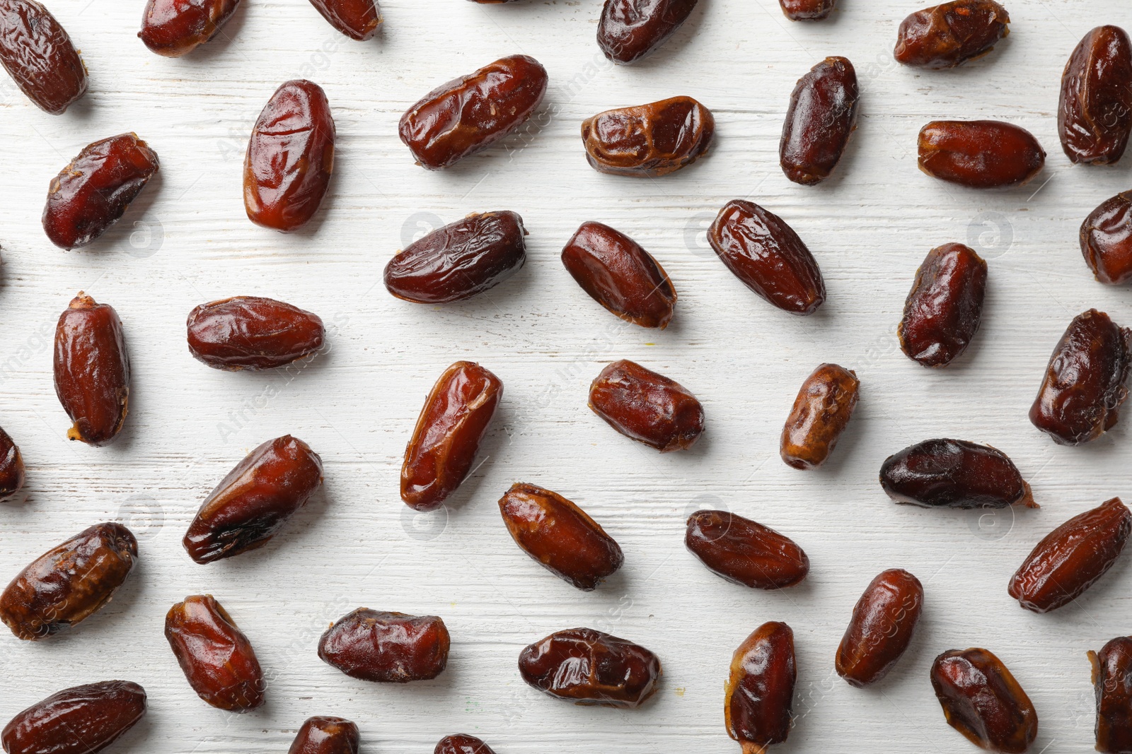 Photo of Flat lay composition with dates on wooden background. Dried fruit as healthy snack