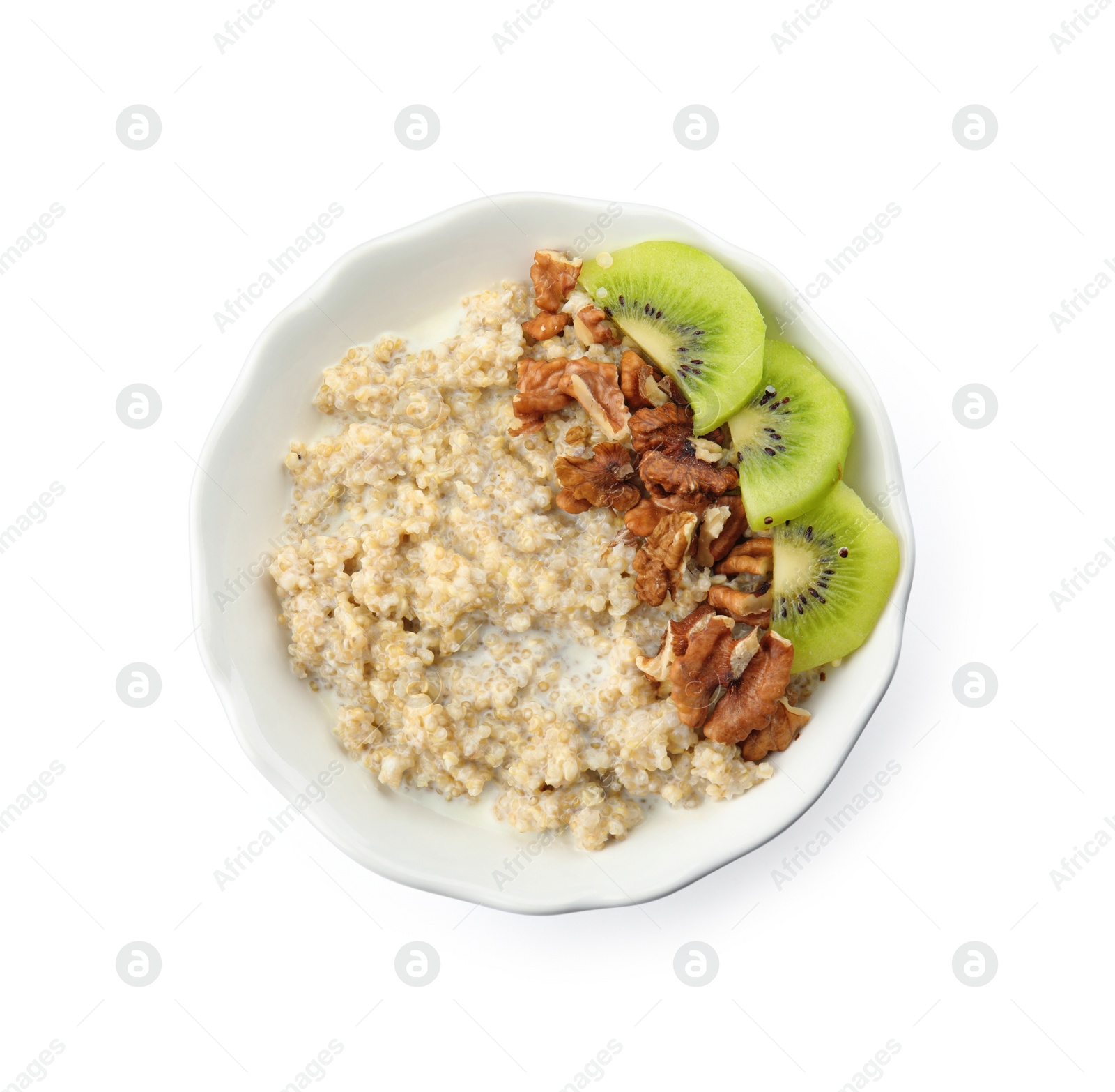 Photo of Bowl of quinoa porridge with walnuts, kiwi and milk on white background, top view