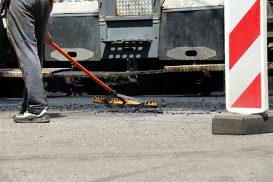 Photo of Worker laying new asphalt with paver, closeup. Road repair