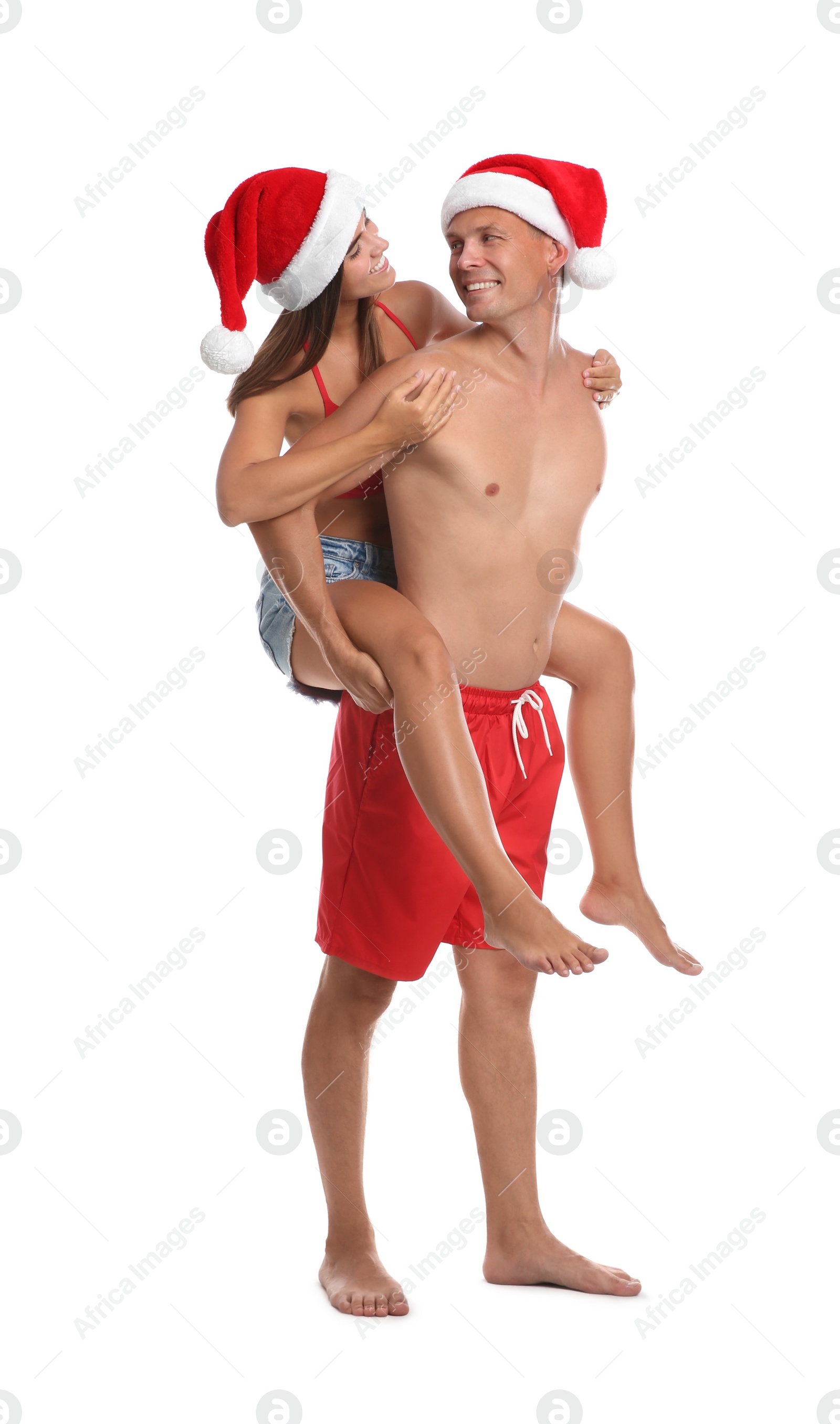 Photo of Happy couple with Santa hats together on white background. Christmas vacation