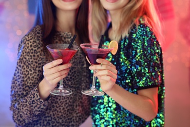 Young women with martini cocktails in bar, closeup