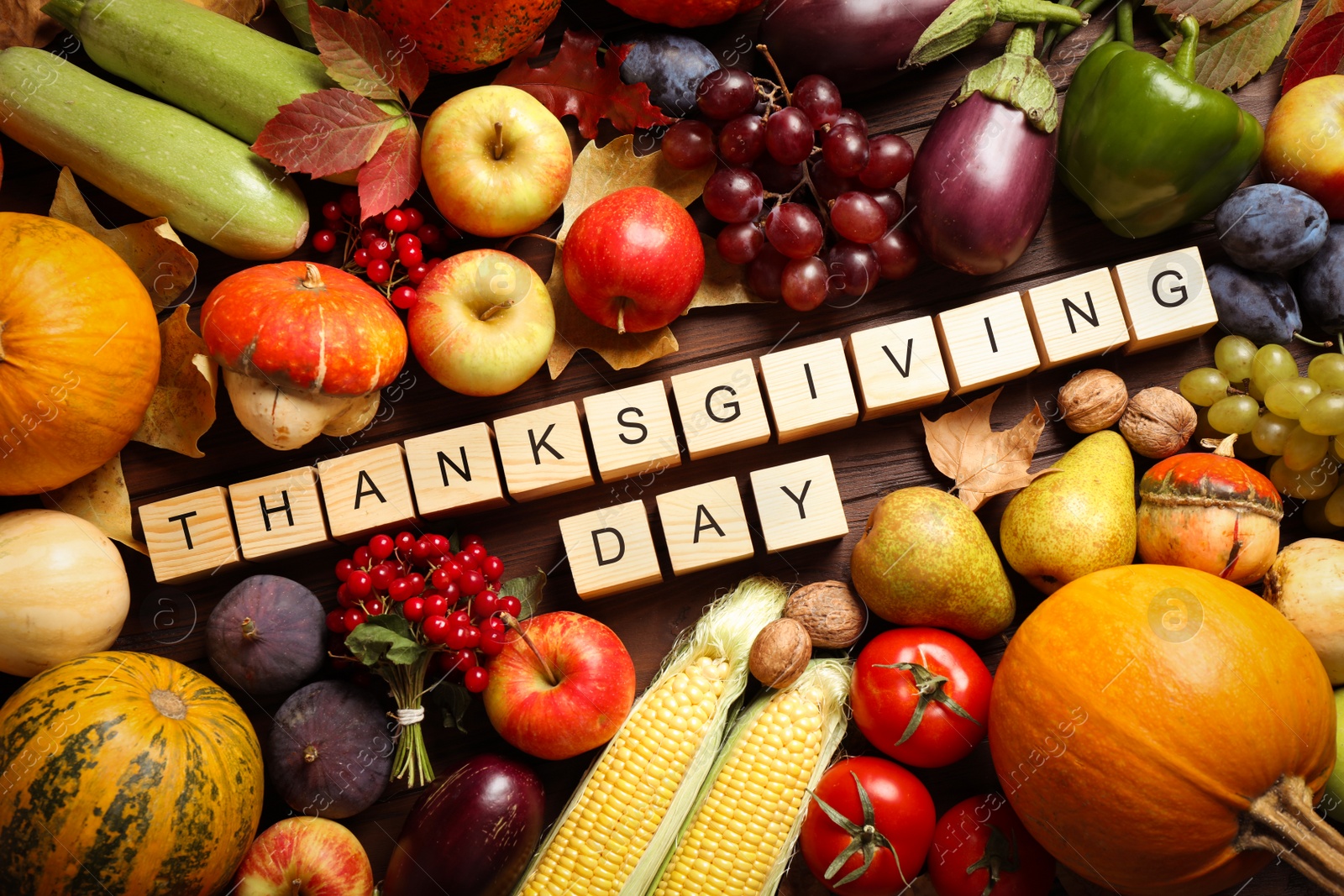 Photo of Cubes with phrase THANKSGIVING DAY, autumn fruits and vegetables on wooden background, flat lay. Happy holiday