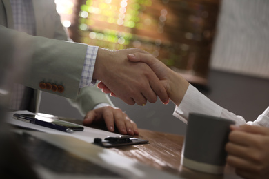 Business people shaking hands in office, closeup