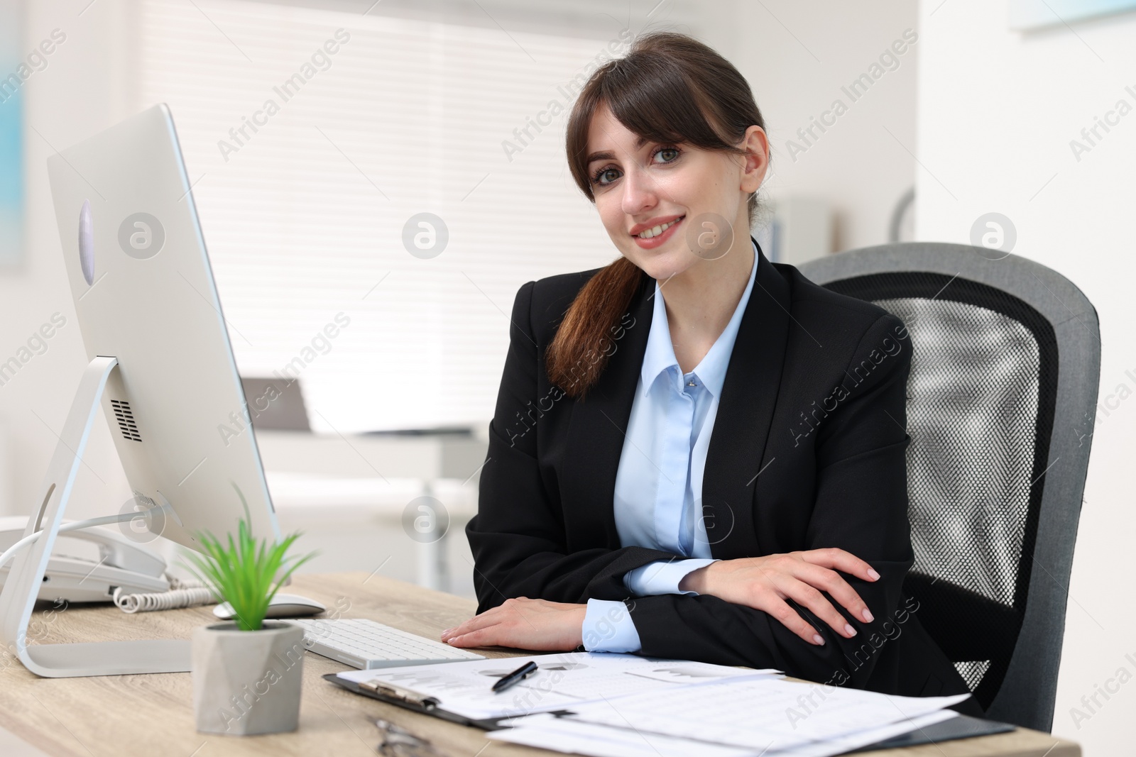 Photo of Portrait of smiling secretary at table in office