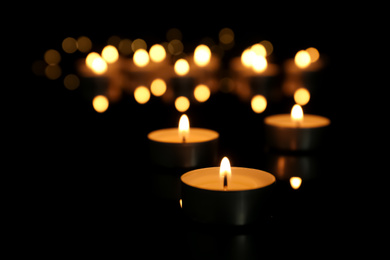 Burning candle on table against blurred background