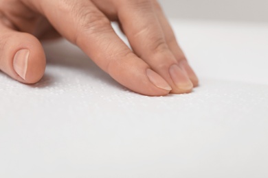 Photo of Blind woman reading book written in Braille, closeup