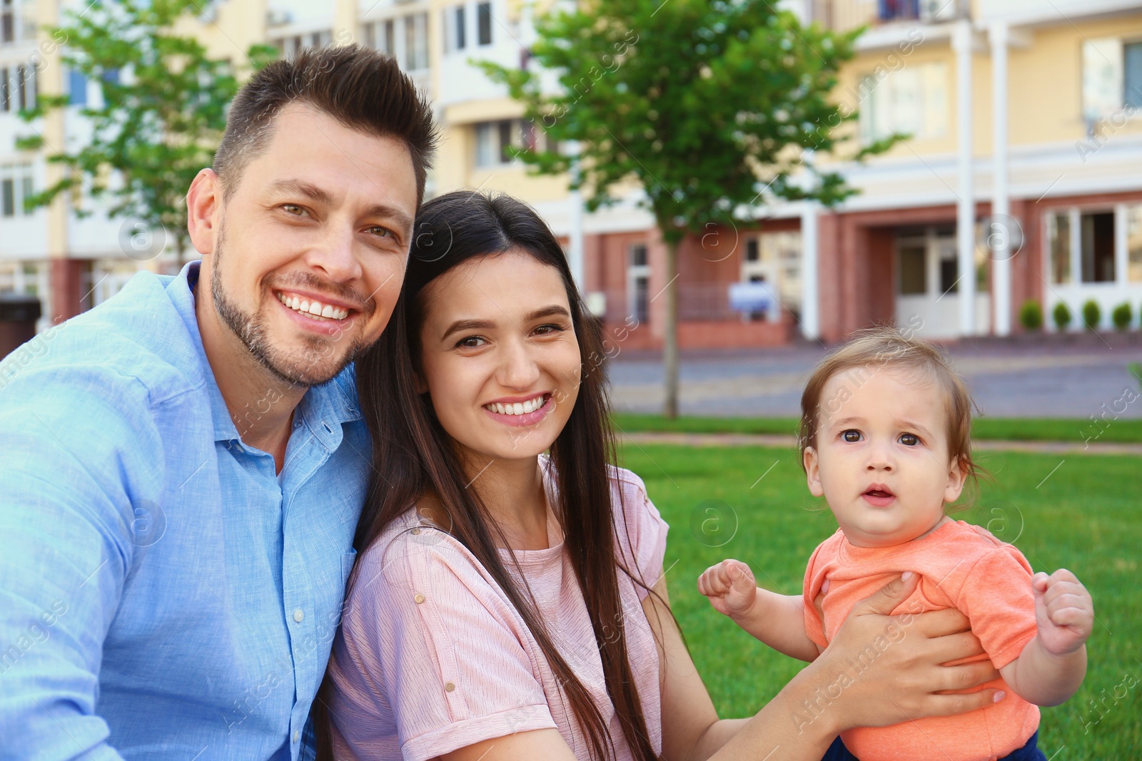 Photo of Happy family with adorable little baby outdoors