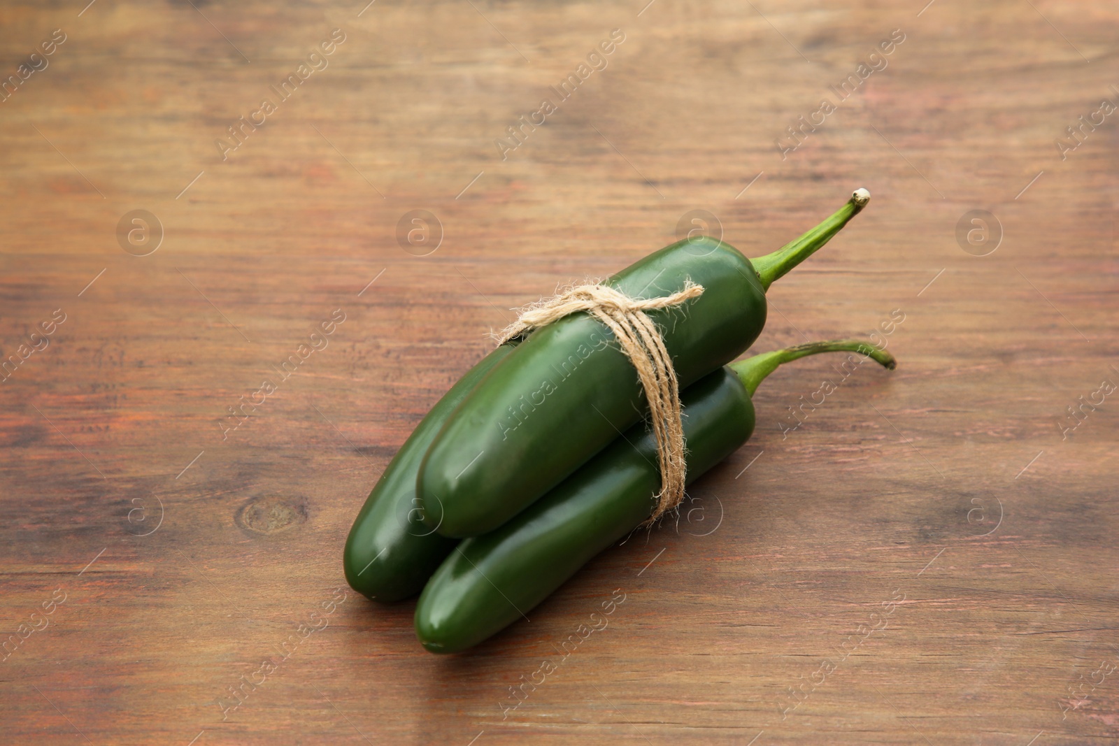Photo of Fresh ripe green jalapeno peppers on wooden table