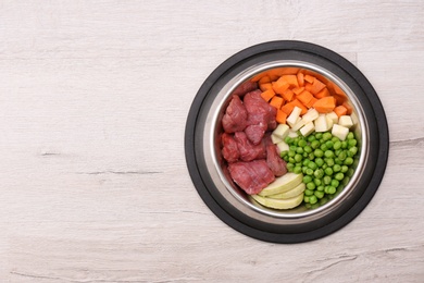 Bowl with organic dog food on light background, top view. Space for text