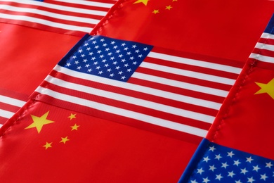 USA and China flags as background, closeup. International relations