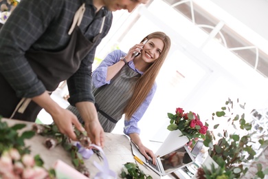 Male and female florists working in flower shop