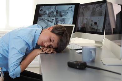 Photo of Female security guard sleeping at workplace indoors