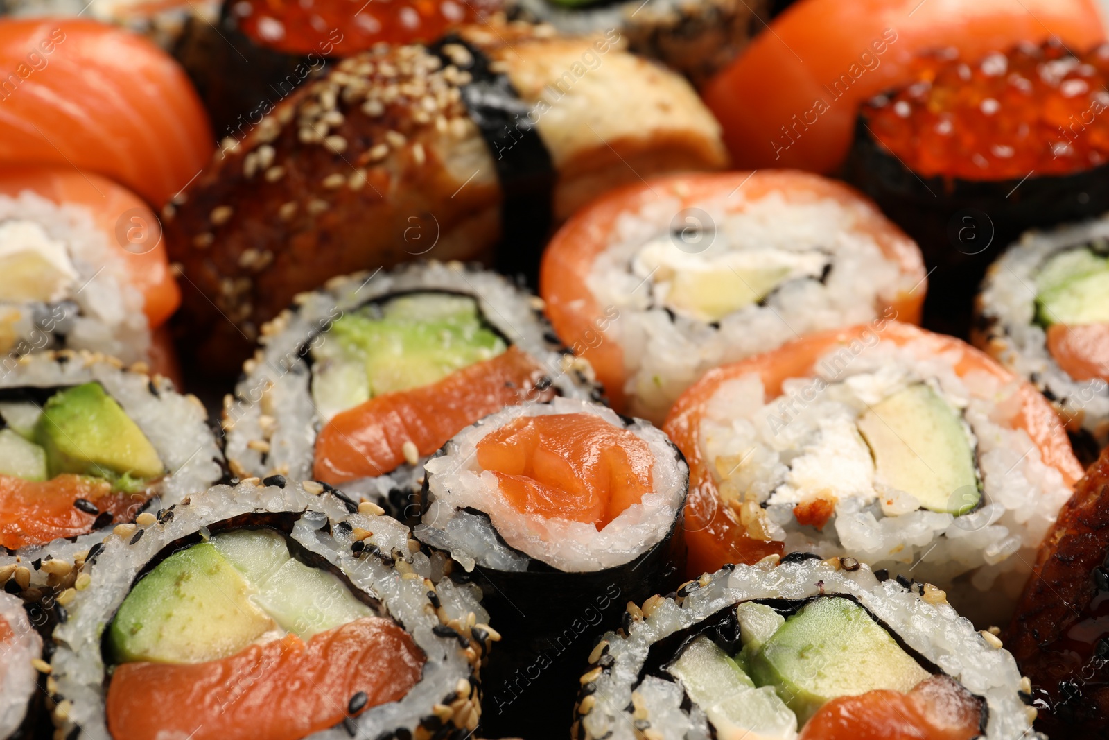 Photo of Different tasty sushi rolls as background, closeup