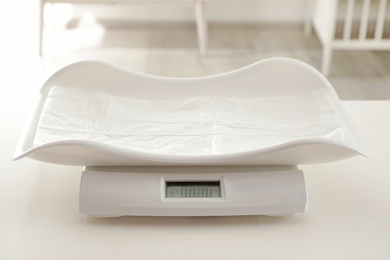 Modern digital baby scales on table in room