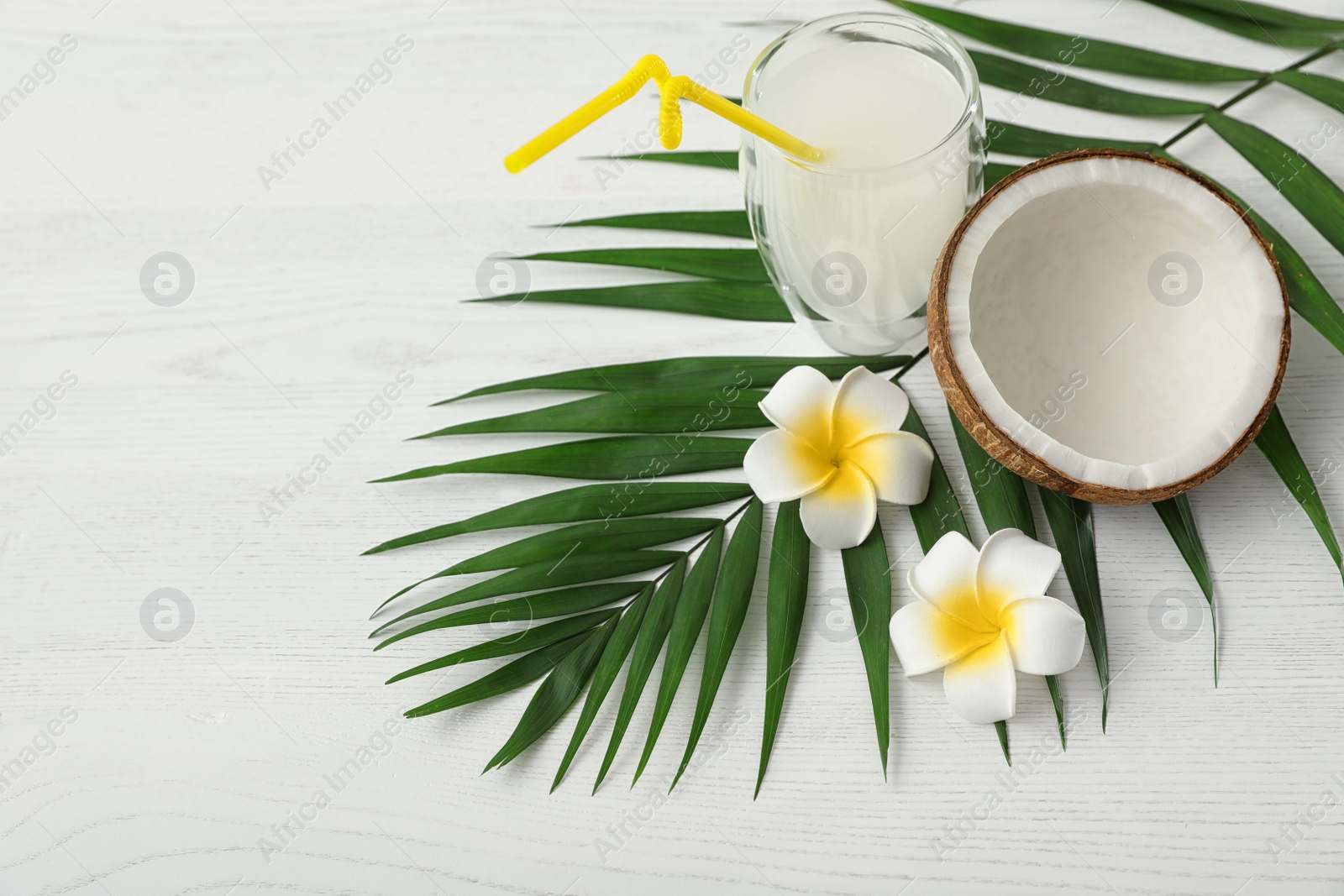 Photo of Composition with glass of coconut water on white wooden background