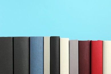 Photo of Many different hardcover books on light blue background, space for text