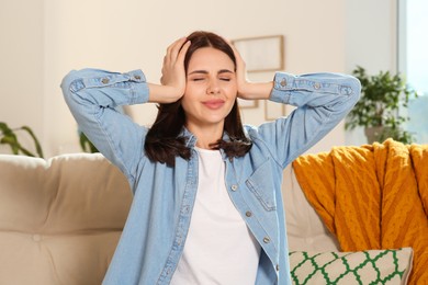 Young woman suffering from headache indoors. Hormonal disorders
