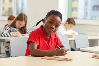 Photo of Portrait of cute little boy studying in classroom at school