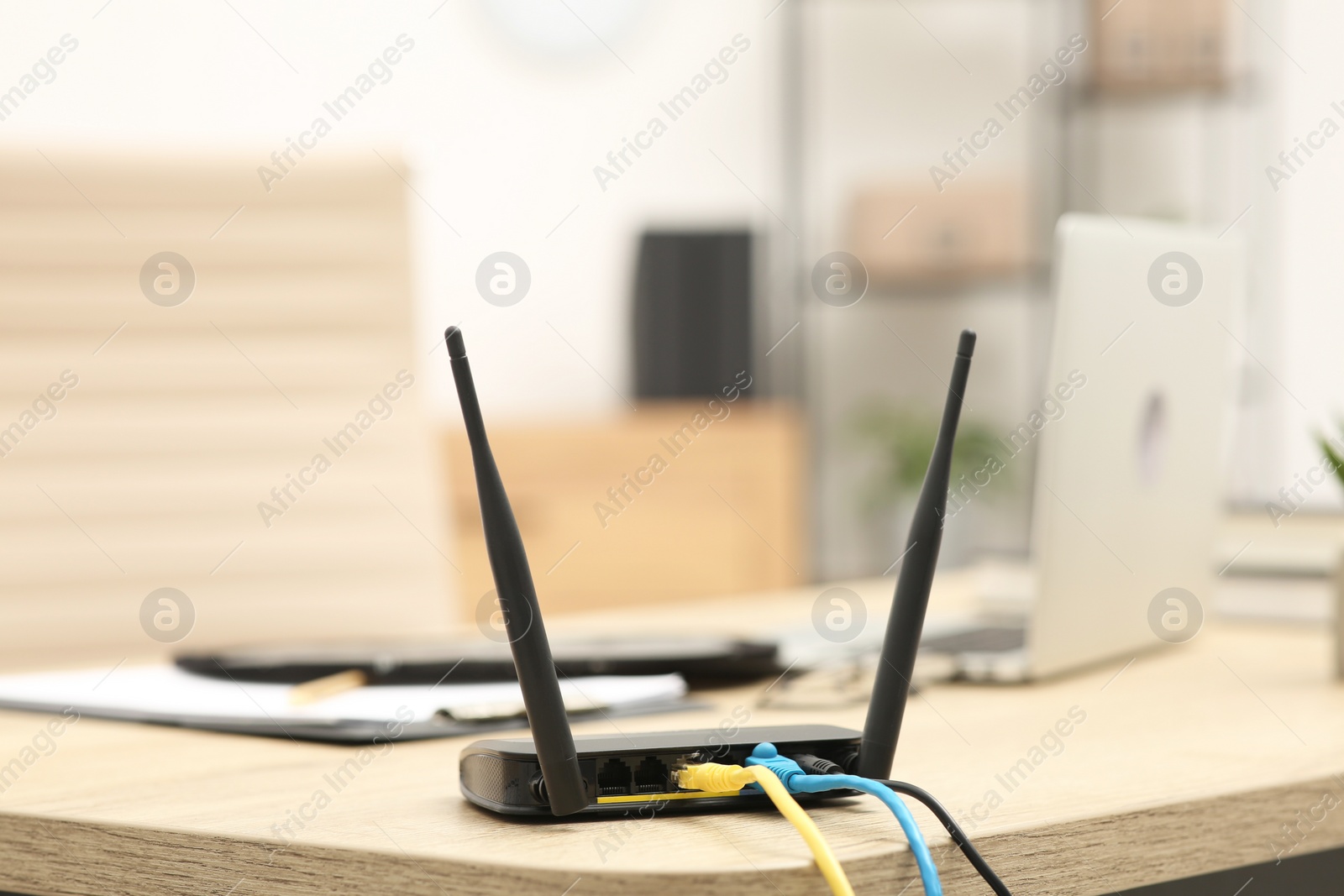 Photo of Modern Wi-Fi router on wooden table indoors