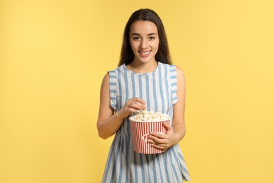 Photo of Woman with popcorn during cinema show on color background