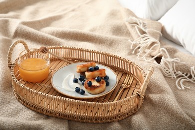 Photo of Delicious cottage cheese pancakes with fresh blueberries and sour cream served on bed tray