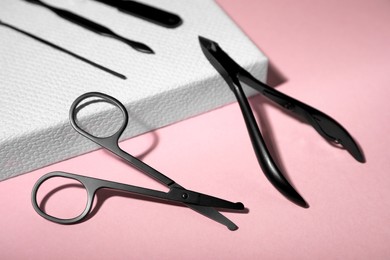 Set of manicure tools on pink background, closeup view