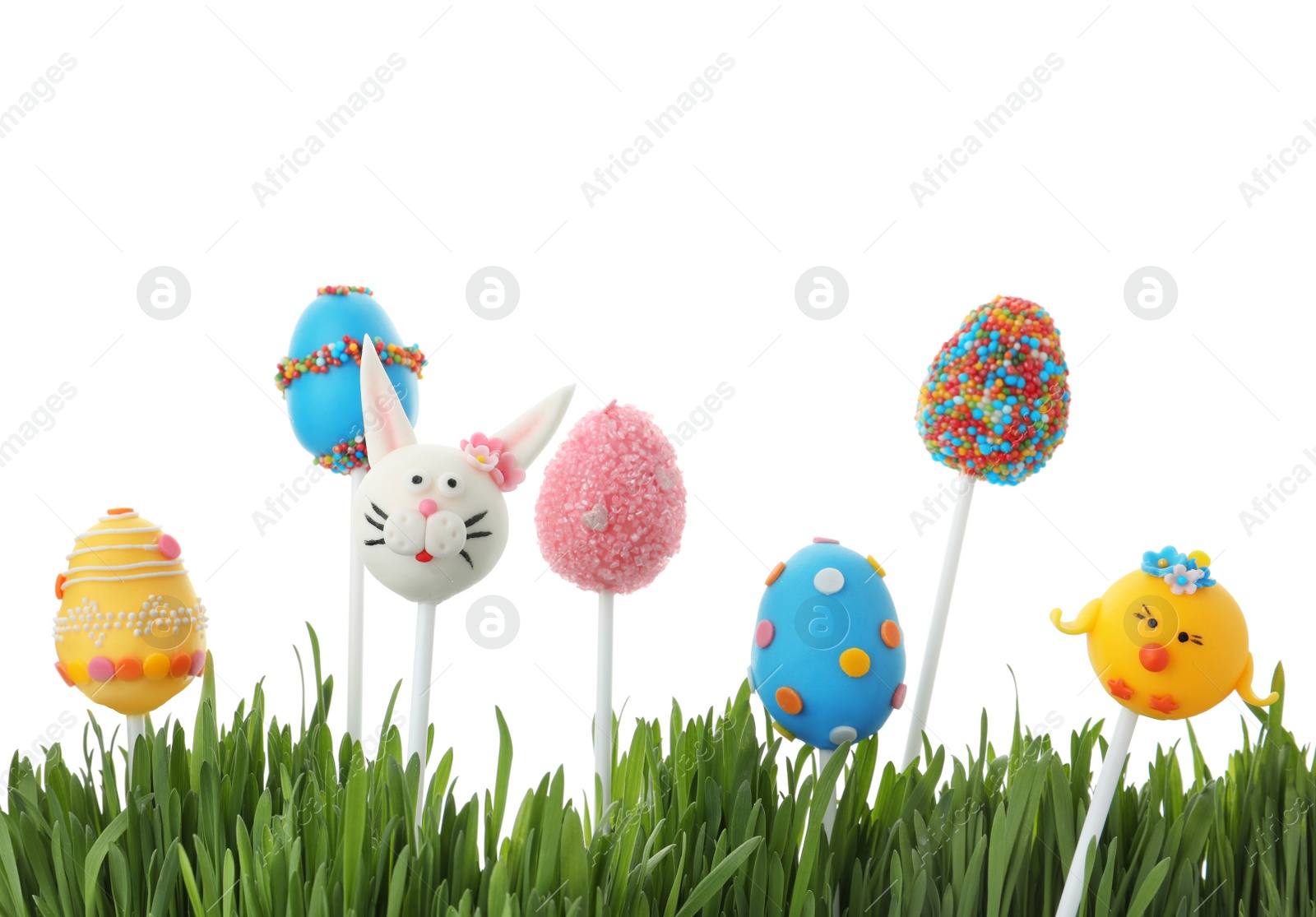 Photo of Different delicious cake pops for Easter celebration and grass on white background