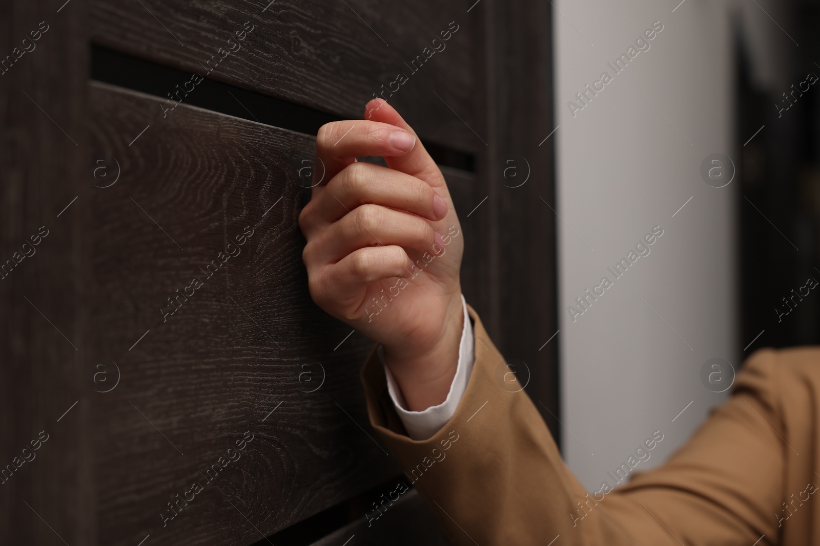 Photo of Collector knocking on door indoors, closeup view