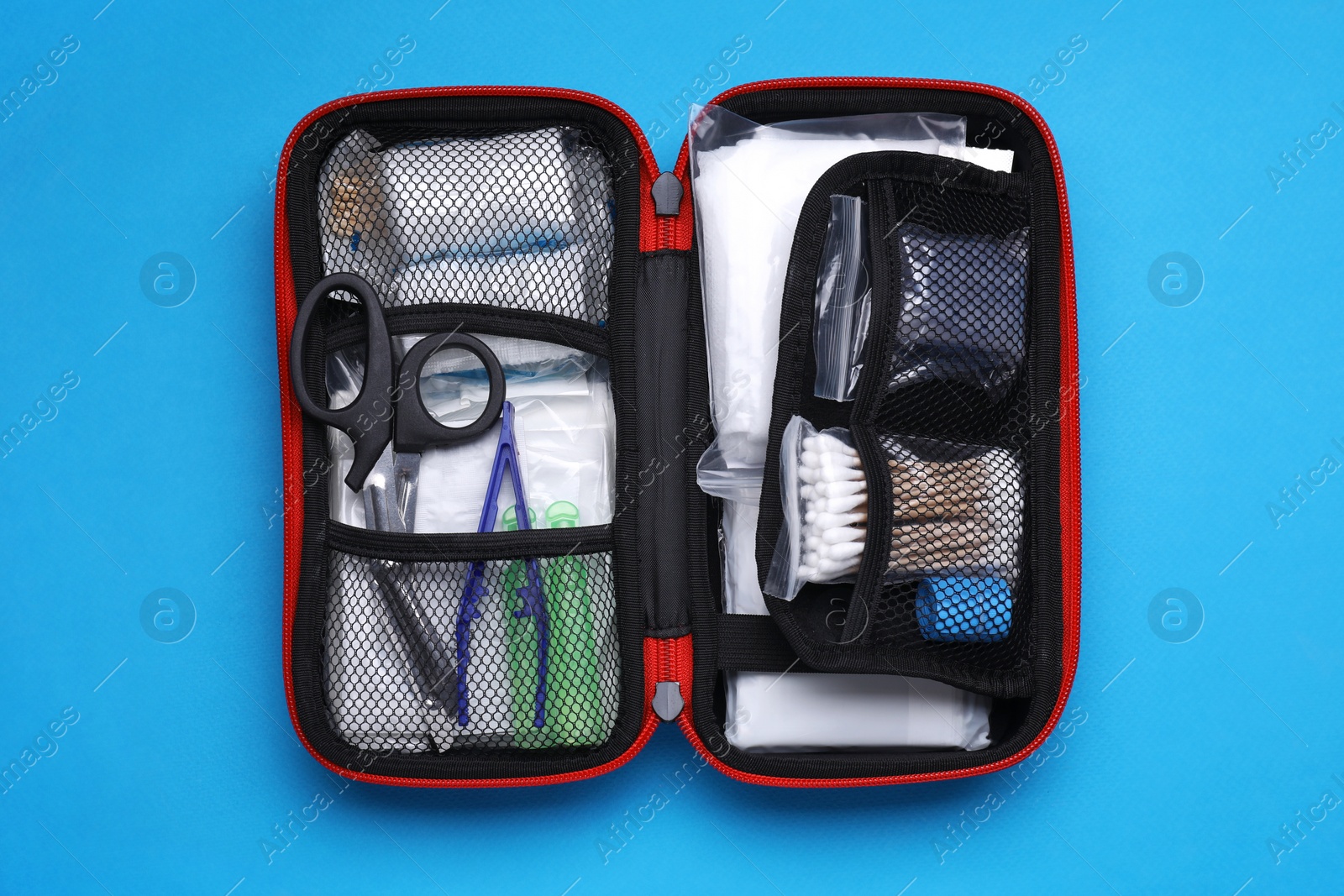 Photo of First aid kit on light blue background, top view