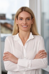 Photo of Portrait of confident entrepreneur or businesswoman with crossed arms. Beautiful lady with blonde hair smiling and looking into camera
