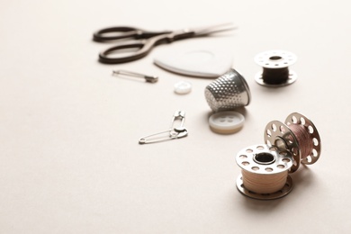 Photo of Metal spools with threads on table. Tailoring equipment