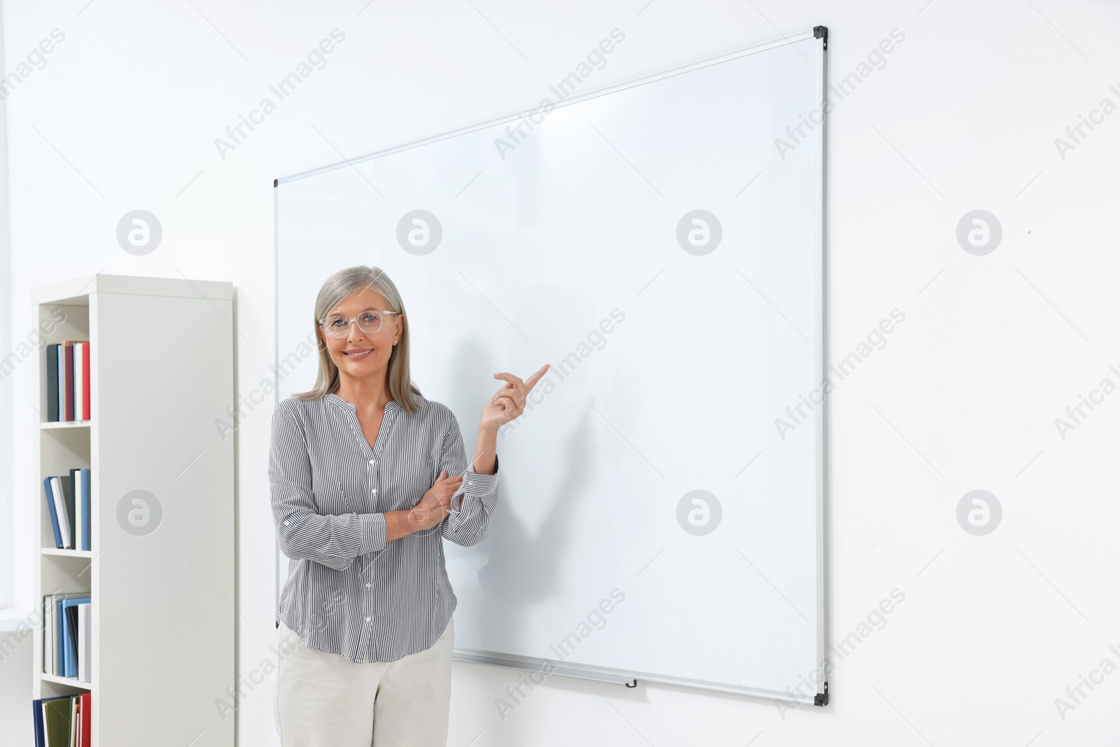 Photo of Professor giving lecture near whiteboard in classroom, space for text