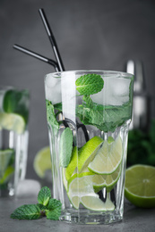 Glass of fresh Mojito cocktail on grey table, closeup