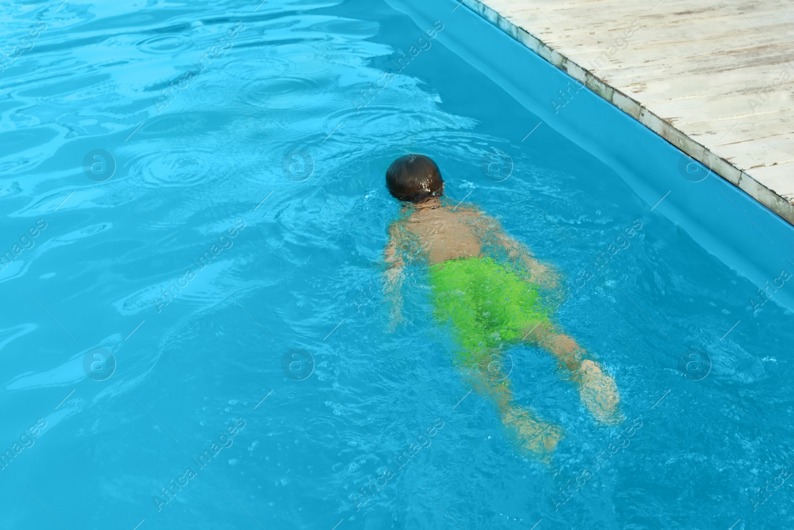 Photo of Little child in outdoor swimming pool. Dangerous situation