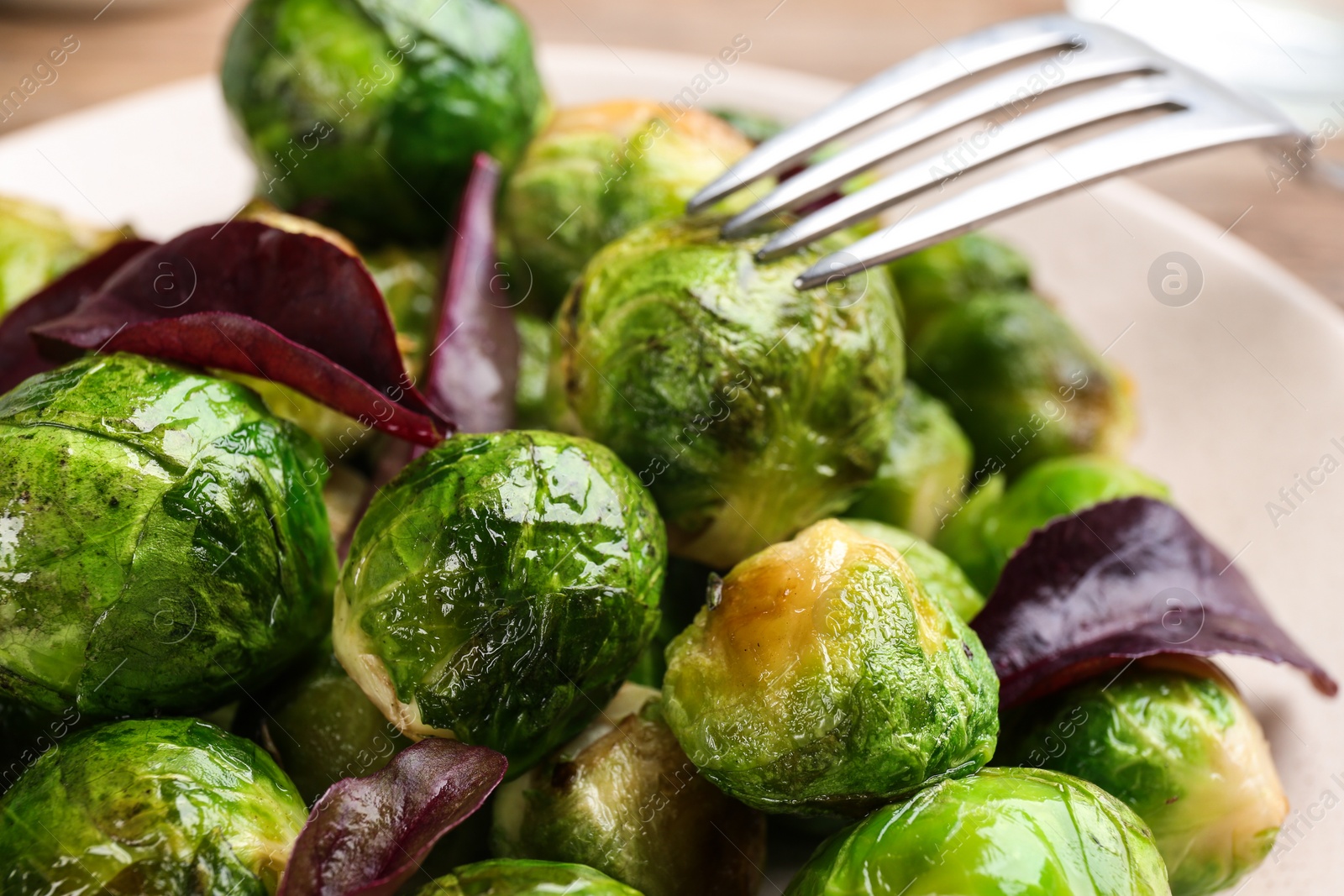 Photo of Delicious roasted Brussels sprouts with basil, closeup