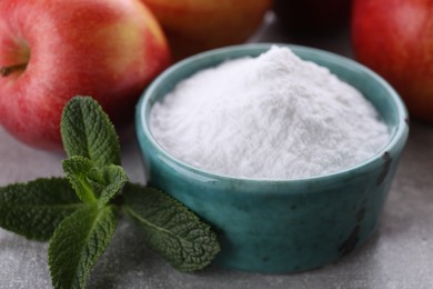 Photo of Sweet fructose powder, mint leaves and apples on light grey table, closeup