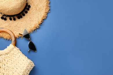 Flat lay composition with straw hat on blue background