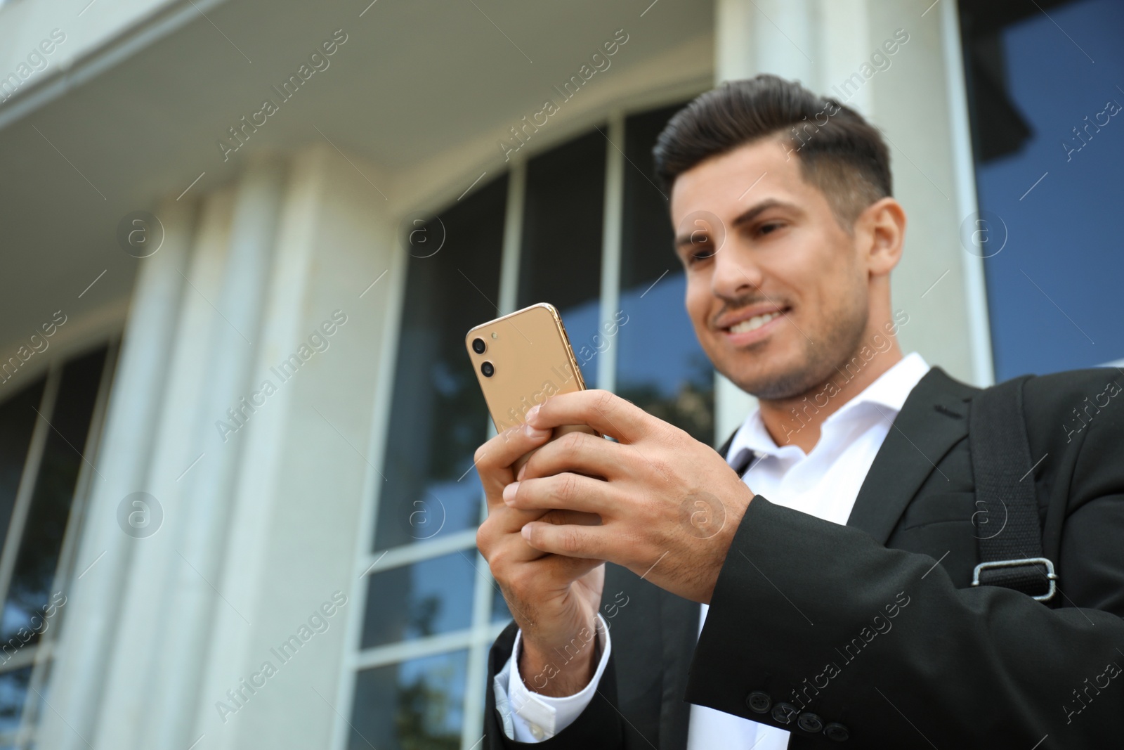 Photo of Handsome man with smartphone on city street