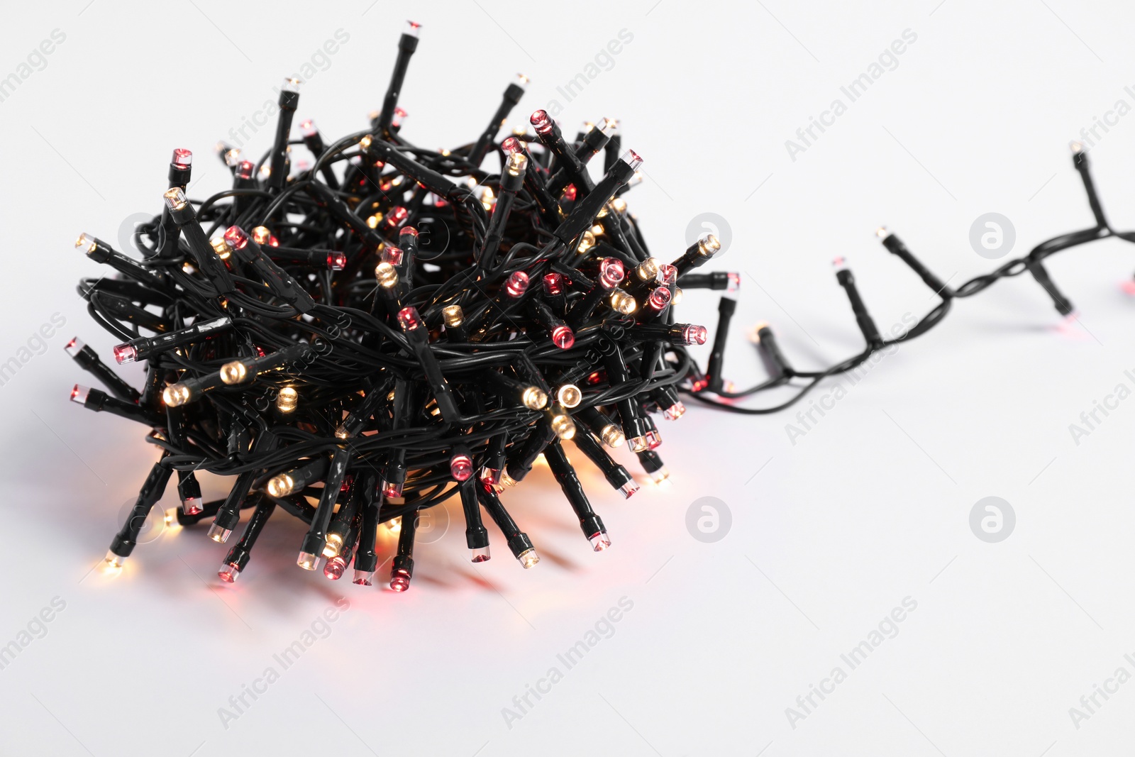 Photo of Bundle of beautiful Christmas lights on white background