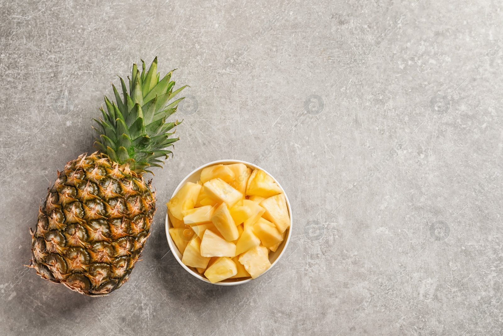 Photo of Fresh whole and sliced pineapple on grey background